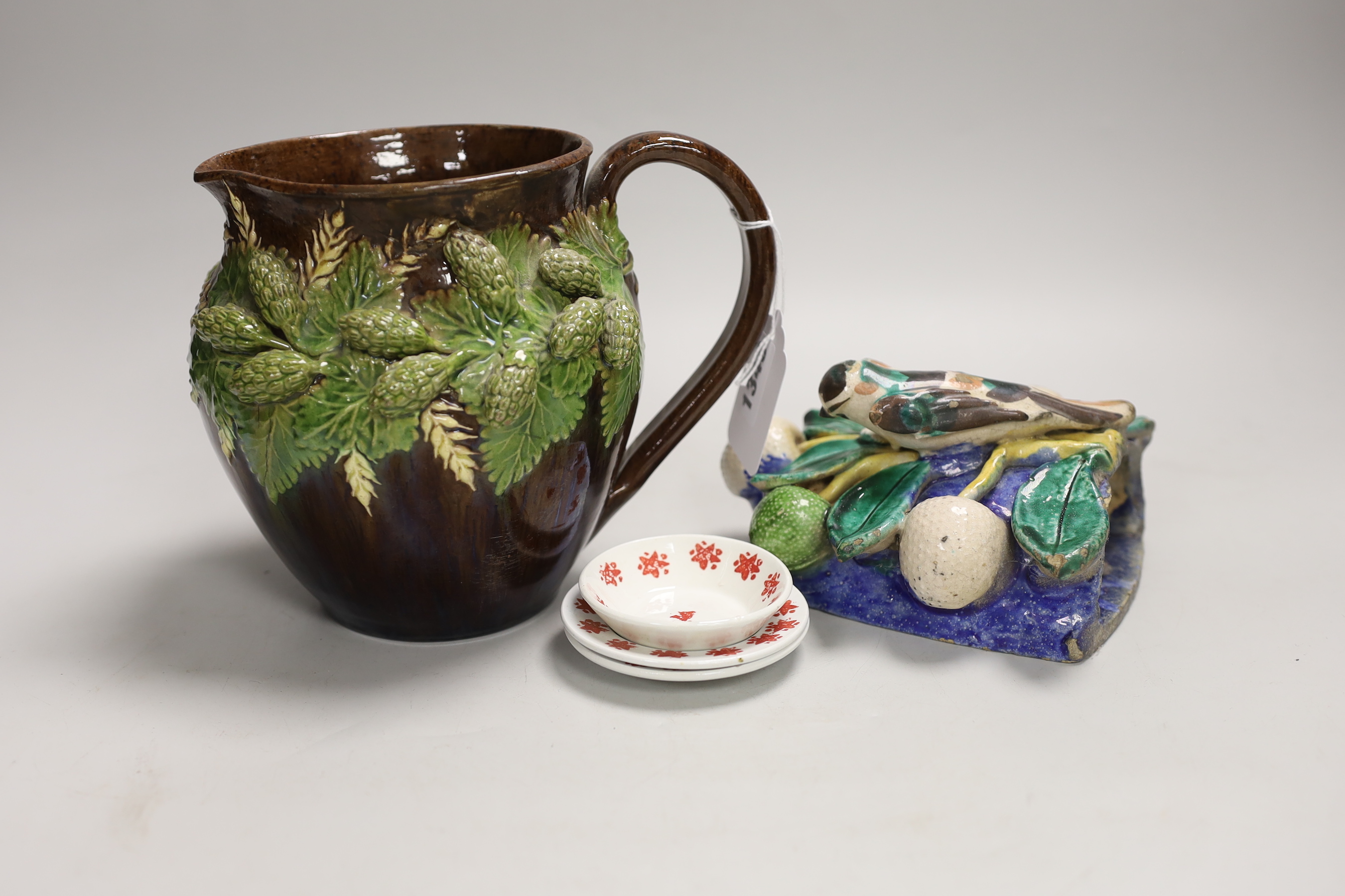 A Portuguese maiolica pottery wall pocket, a Rye pottery jug and three creamware dolls house plates